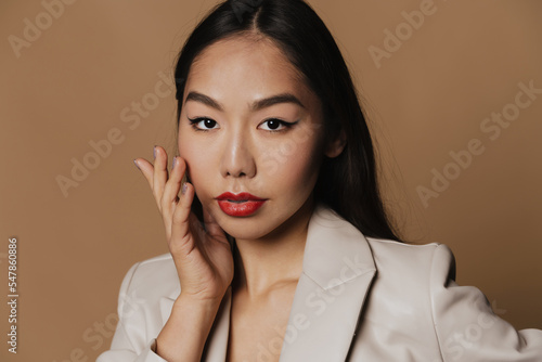 Young asian woman wearing jacket posing and looking at camera