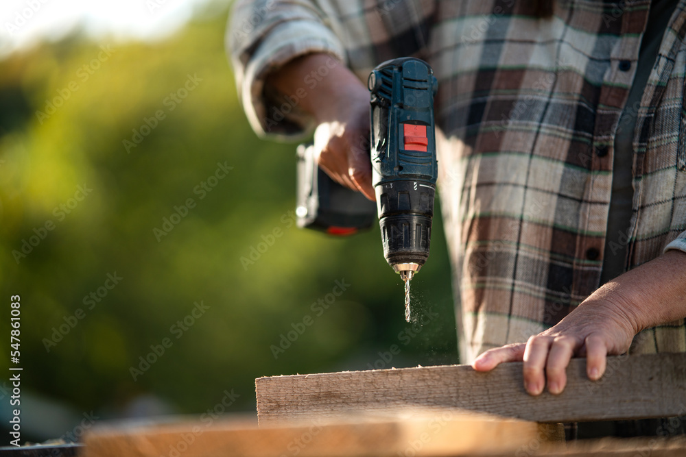 Close-up of handy female carpenter working in carpentry diy workshop outdoors