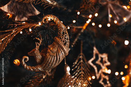 Vintage New Year golden toy moon hanging on the Christmas tree. Winter holiday magic season, bokeh lights © asauriet