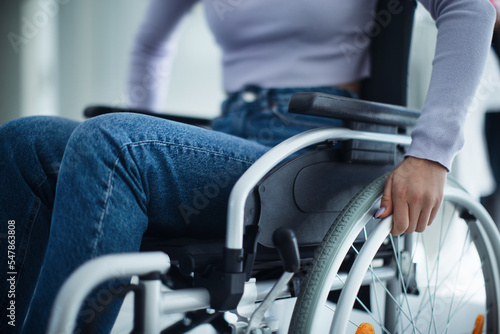 Close-up of young woman at wheelchair in hospital.