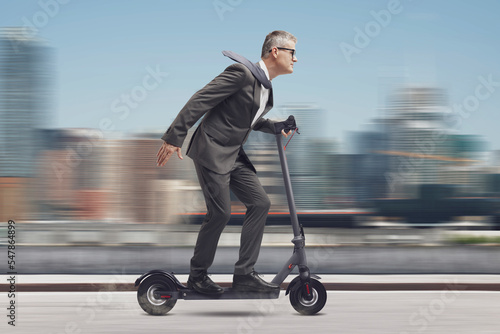 Businessman riding a fast electric scooter