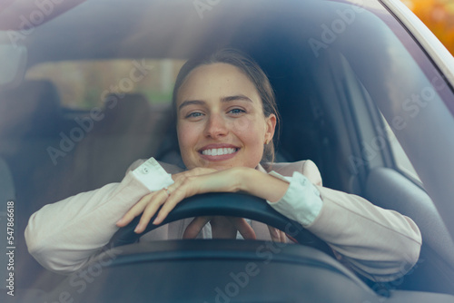 Excited young woman sitting in her car, prepared for driving. photo