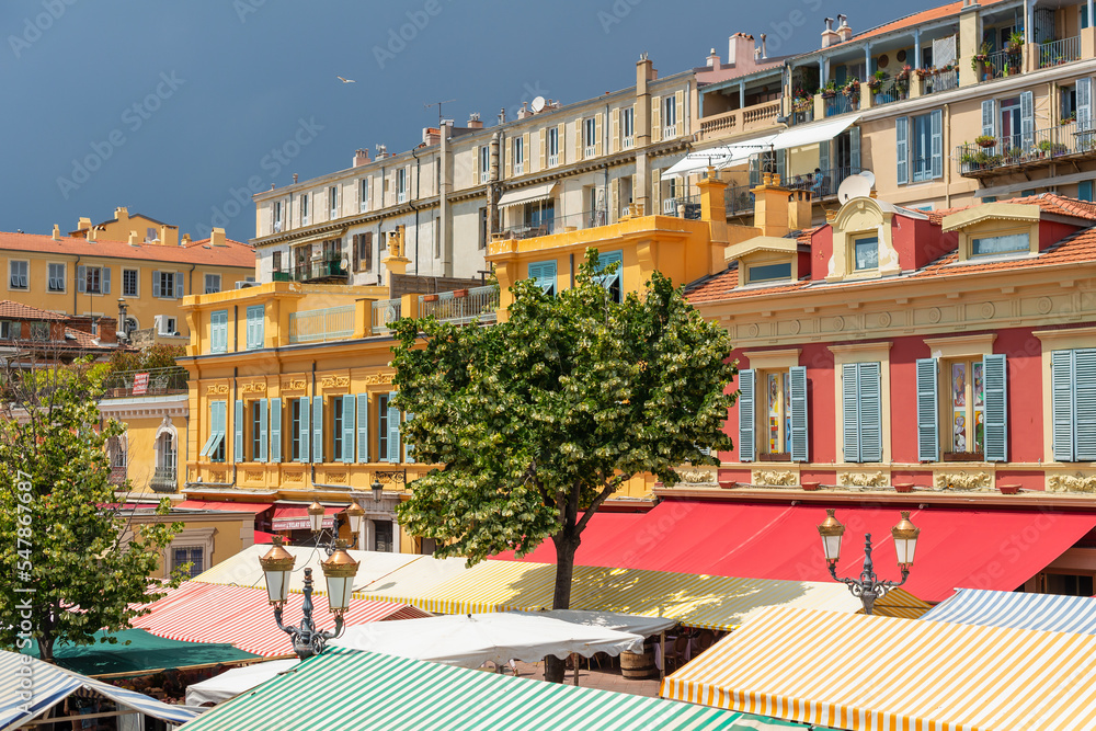 Colourful building facades and the traditional Cours Saleya, daily outdoor market, in the heart of the Old Town, Vieux Nice, France, on a summer day in the French Riviera
