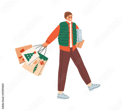 Happy man walking with Christmas gifts, shopping bags on street. Person going...
