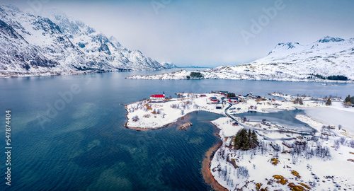 Picturesque winter view from flying drone of red roof Sildpollnes Church. Aerial morning view of Lofoten islands, Vestpollen, Norway, Europe. Traveling concept background.. photo