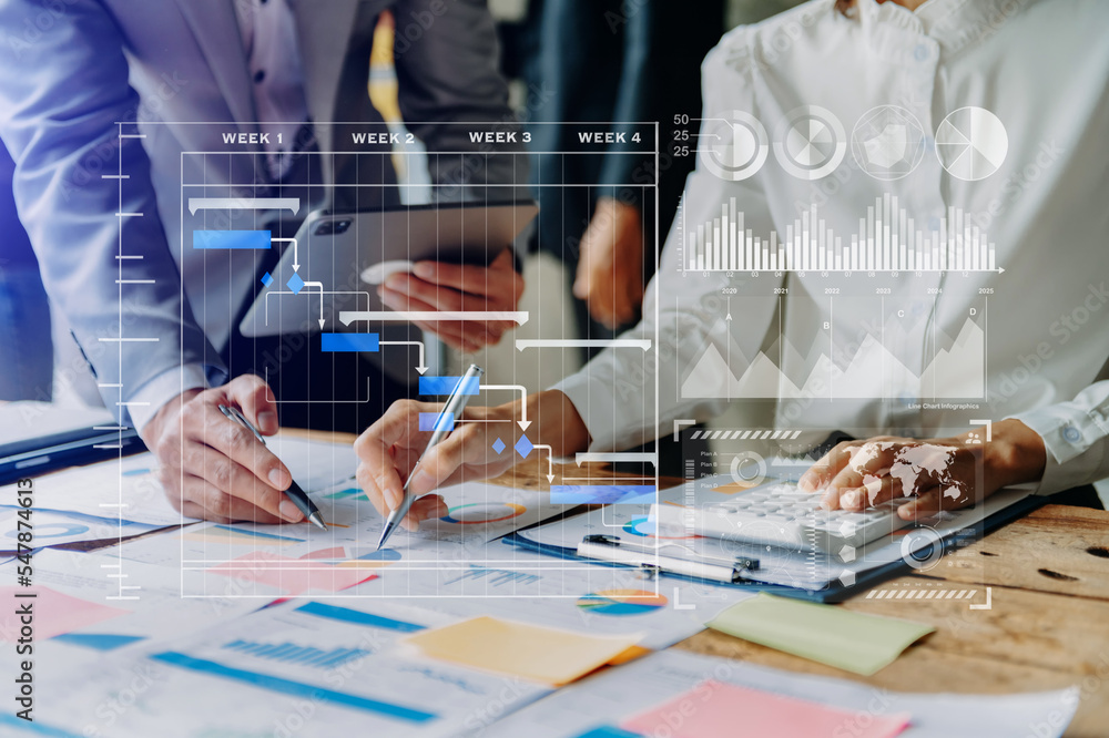 Businessman hand Project manager working and update tasks and Gantt chart scheduling virtual diagram.with smart phone, tablet and laptop in office. Businessman hand Project manager working and update tasks and Gantt chart scheduling virtual diagram.with smart phone, tablet and laptop in office.