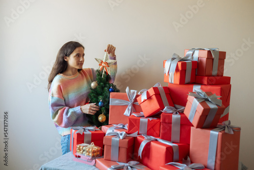 beautiful girl in the process of decorating the Christmas tree photo