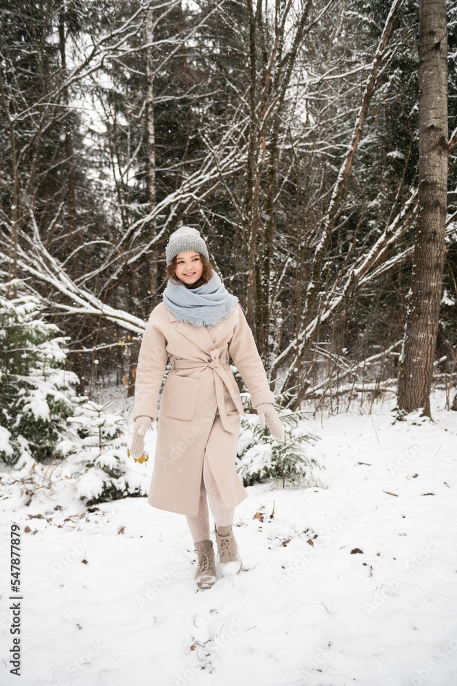 A cute girl walks through a winter forest A cute girl walks through a winter forest
