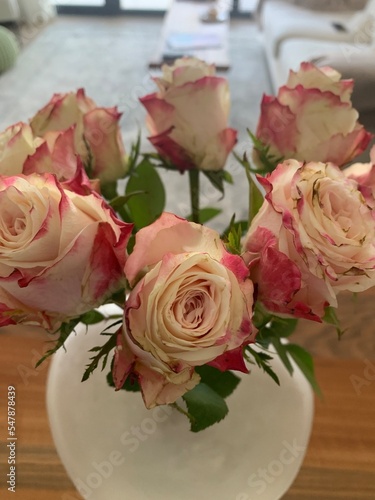 Close up image of a bouquet of pink and white roses in a vase