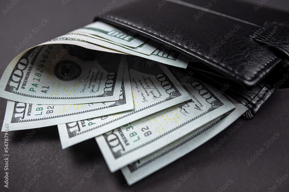 wallet full of money on wooden table one hundred US bills with portrait of President Franklin wallet full of money on wooden table one hundred US bills with portrait of President Franklin