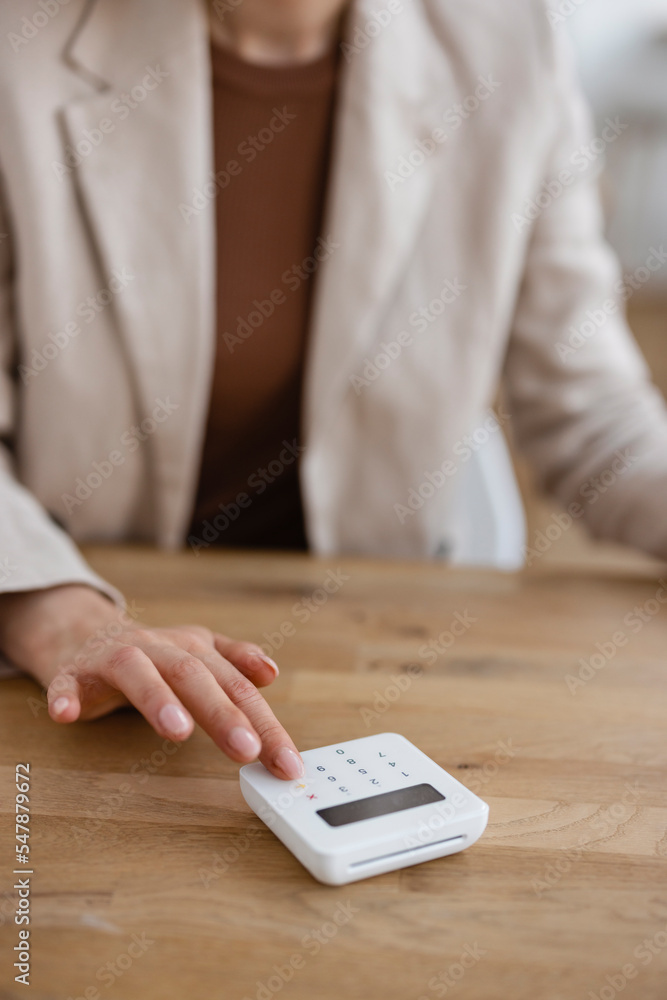 Hand of businesswoman using credit card reader on table in office