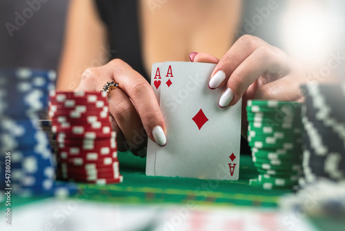 Obraz na plátne young beautiful lady croupier with artistic joker makeup on red background holdi