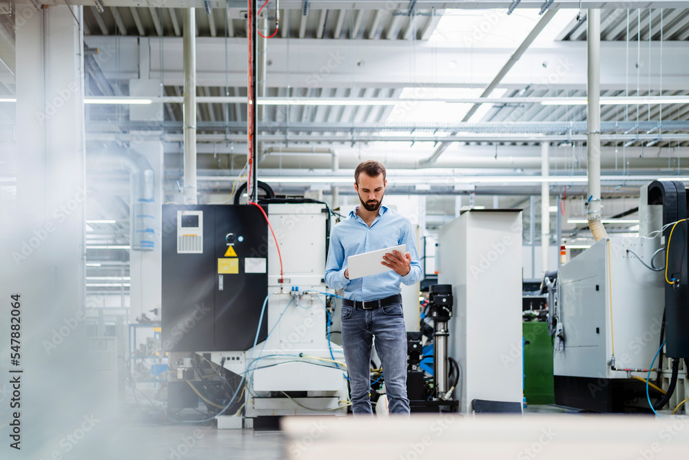 Businessman using tablet PC standing in industry Businessman using tablet PC standing in industry