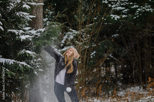 middle-aged woman under the Christmas tree in the woods before christmas