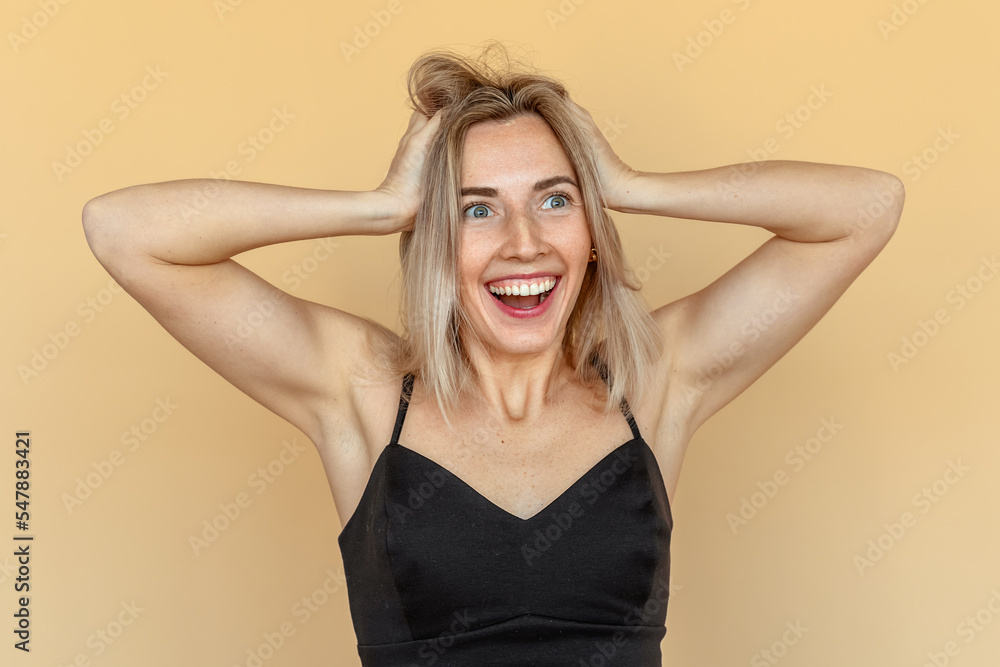 Amazed pretty young woman with freckles touch hands hair. Beautiful girl surprised and wondered looks aside. Expressive facial expressions Amazed pretty young woman with freckles touch hands hair. Beautiful girl surprised and wondered looks aside. Expressive facial expressions