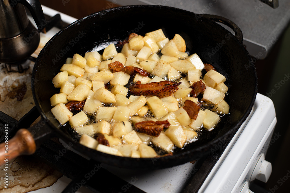Cooking fried potatoes with lard, cracklings in a pan. Cooking fried potatoes with lard, cracklings in a pan.