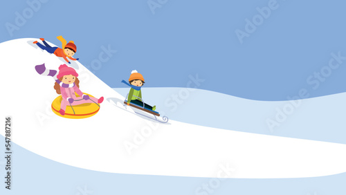 Three children ride on a hill in winter