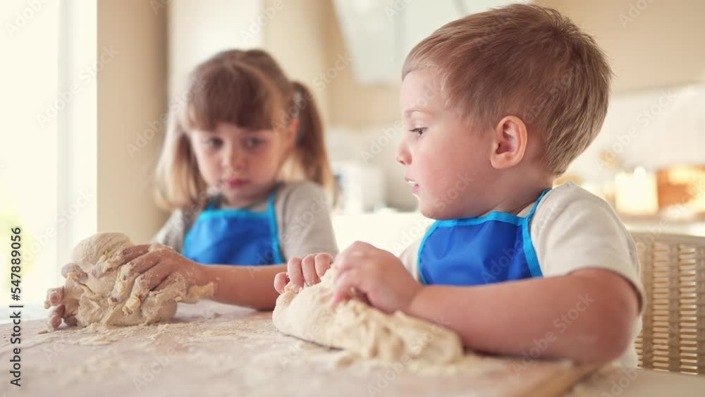 children making dough in the kitchen. baby boy cook in the kitchen knead dough and flour indoors. happy family kid dream concept. children play lifestyle cooking dough together at home children making dough in the kitchen. baby boy cook in the kitchen knead dough and flour indoors. happy family kid dream concept. children play lifestyle cooking dough together at home