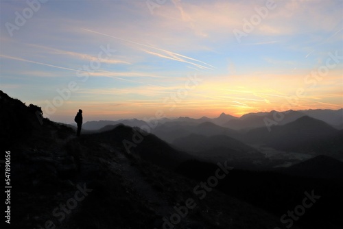 young hiker is standing on a mountain and watching the sunrise  © johannes81