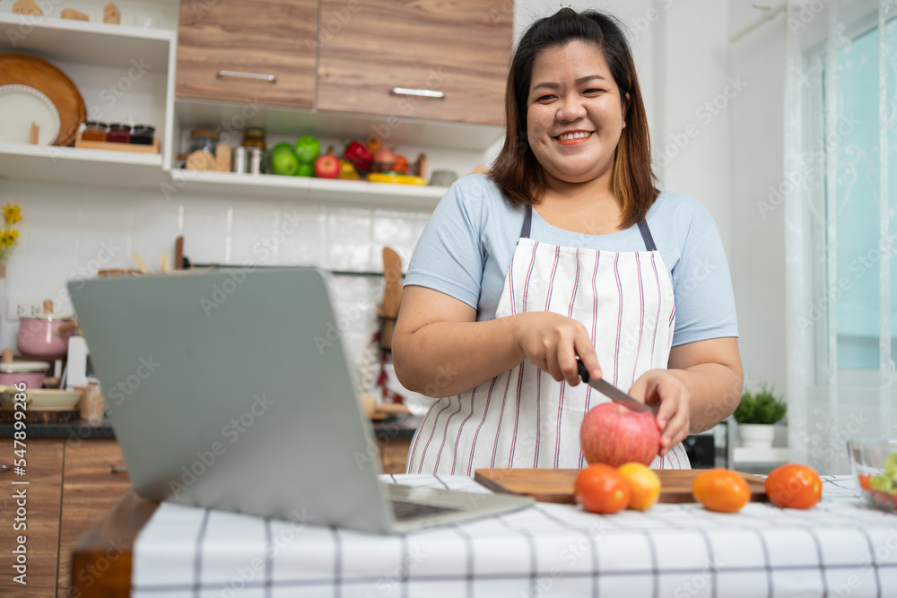 Asian Pregnant learn how to cook healthy meals from the Internet in kitchen, Fat women prepare a vegetable salad for diet food and lose weight. Concept of healthy eating Asian Pregnant learn how to cook healthy meals from the Internet in kitchen, Fat women prepare a vegetable salad for diet food and lose weight. Concept of healthy eating