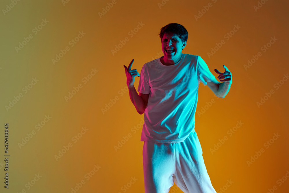 Fototapeta premium man dancing on yellow background. Neon lighting