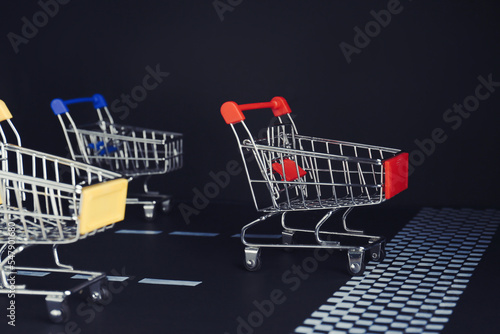 Competition concept. Shopping carts racing towards finish line
