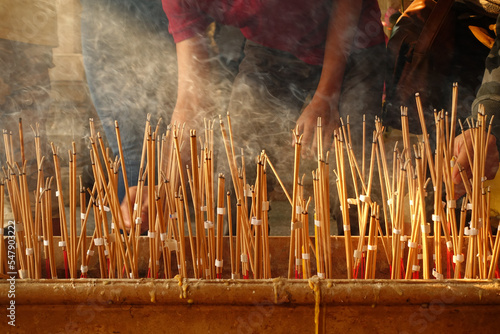 Hand lace incense on joss stick pot to make a wish,Incense that was lit to worship,Make merit for Temple Thailand photo