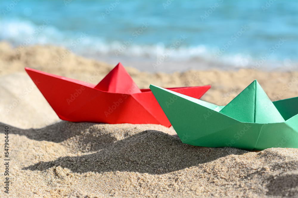 Two paper boats near sea on sunny day, closeup Two paper boats near sea on sunny day, closeup