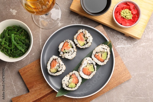 Flat lay composition with delicious sushi rolls on grey textured table