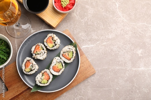 Flat lay composition with delicious sushi rolls on grey textured table. Space for text