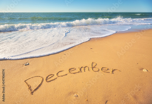 December word on sea sand.