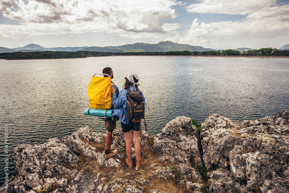 Hikers with backpacks walking enjoying at the mountain lake