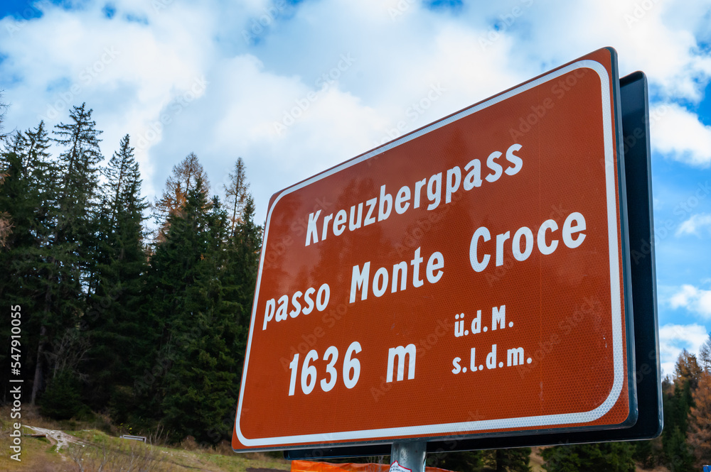 Monte Croce, Italy - November 3, 2022: Road sign for Kreuzberg - Monte Croce, a mountain pass  in Dolomites, between South Tyrol and Belluno