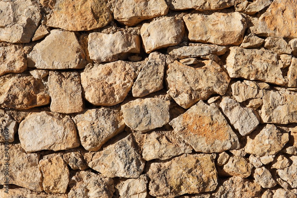 Wall made of rough clear brown stones. Perfect for textures and patterns Wall made of rough clear brown stones. Perfect for textures and patterns