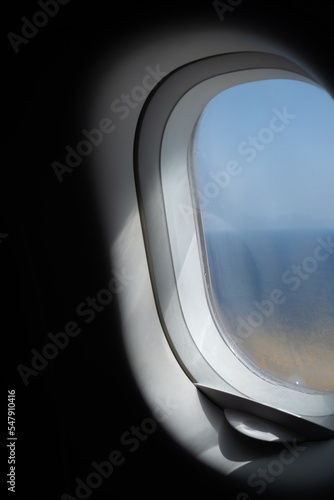 Vista de día soleado desde la ventanilla de avión volando sobre el mar photo