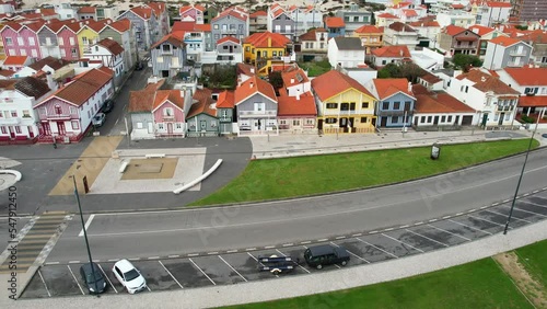 Vibrant houses on the seafront of Costa Nova, Portugal. Tilt down aerial shot