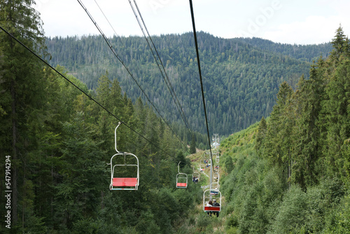 Ski lift and green trees at mountain resort