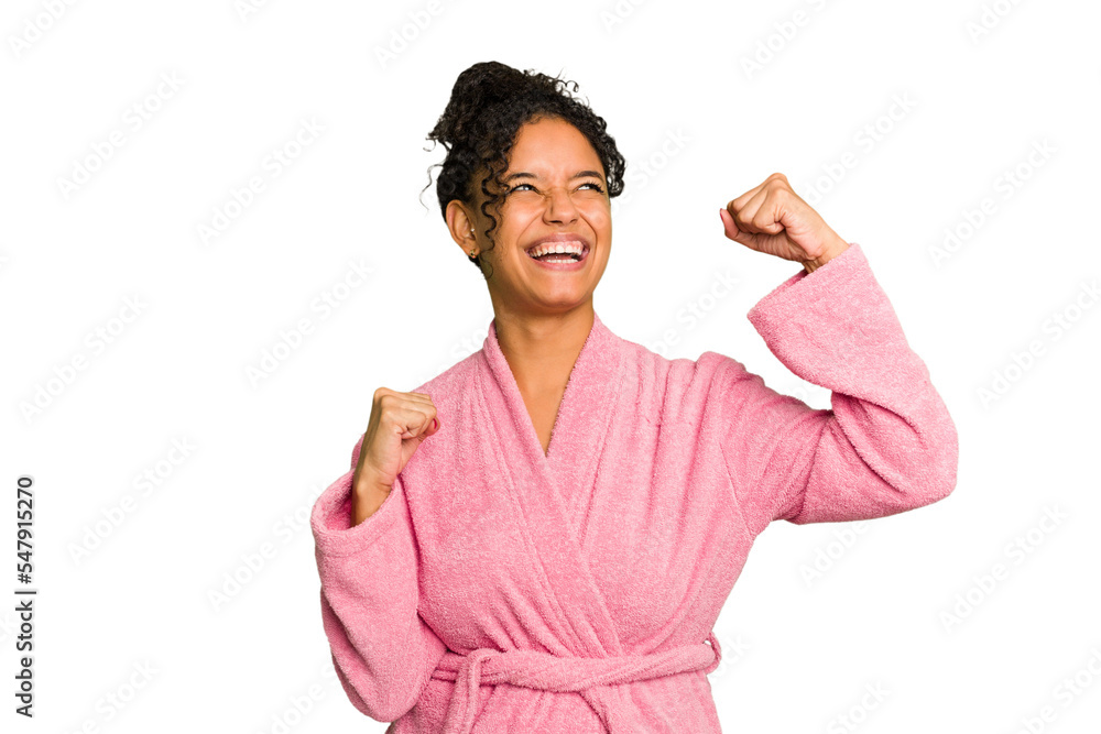 Young brazilian woman wearing a pink bathrobe isolated raising fist after a victory, winner concept. Young brazilian woman wearing a pink bathrobe isolated raising fist after a victory, winner concept.