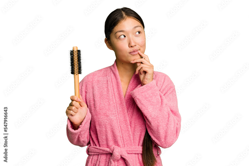 Young asian woman holding an hair comb isolated looking sideways with doubtful and skeptical expression. Young asian woman holding an hair comb isolated looking sideways with doubtful and skeptical expression.