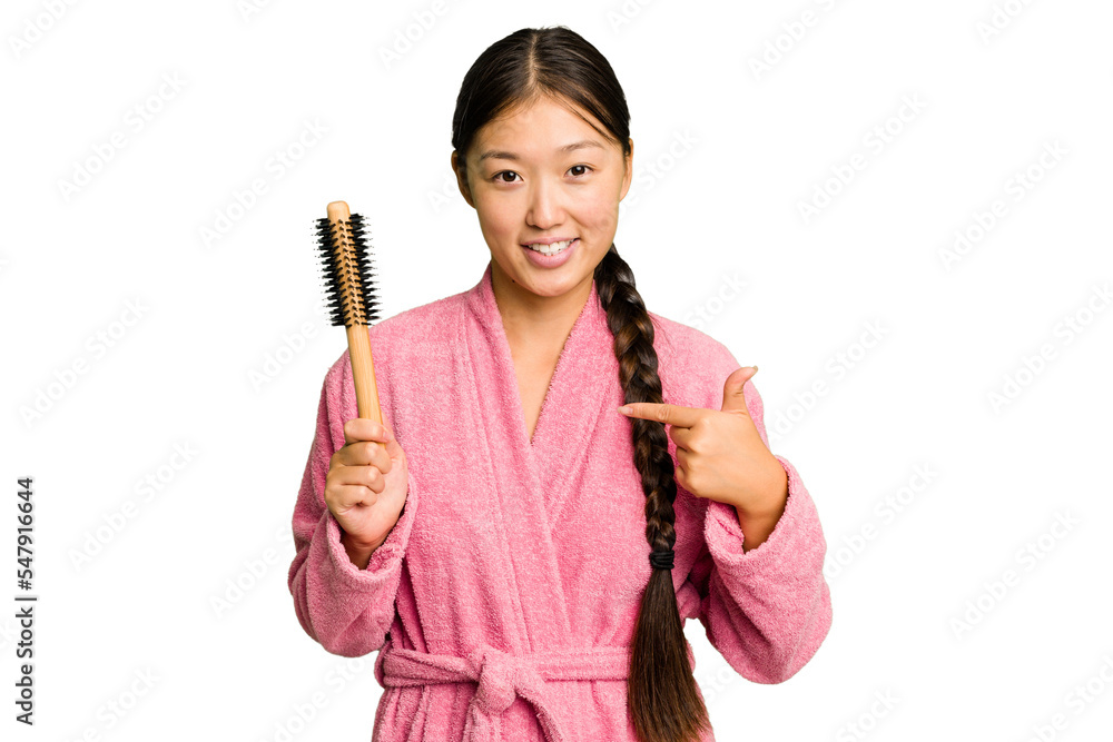 Young asian woman holding an hair comb isolated person pointing by hand to a shirt copy space, proud and confident Young asian woman holding an hair comb isolated person pointing by hand to a shirt copy space, proud and confident