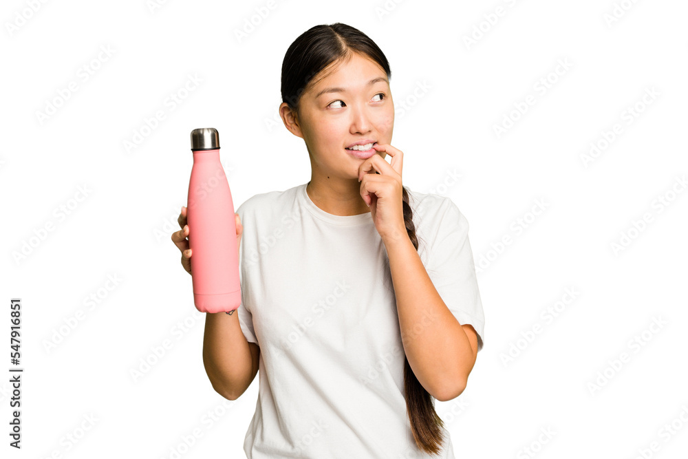 Young asian woman holding a pink thermo isolated relaxed thinking about something looking at a copy space. Young asian woman holding a pink thermo isolated relaxed thinking about something looking at a copy space.