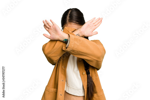 Young Asian woman isolated keeping two arms crossed, denial concept. photo