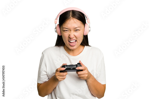 Young asian gamer woman playing with a game controller and headphones isolated