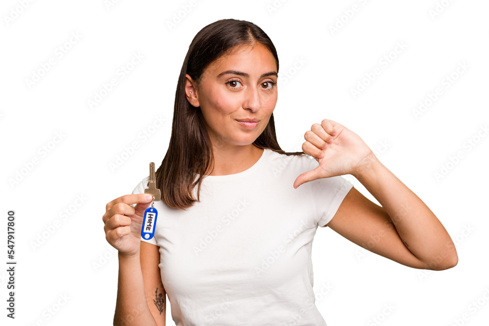 Young caucasian woman holding a home keys isolated feels proud and self confident, example to follow. Young caucasian woman holding a home keys isolated feels proud and self confident, example to follow.