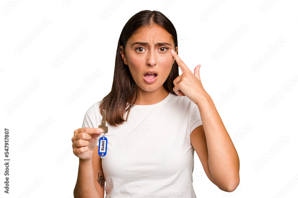 Young caucasian woman holding a home keys isolated showing a disappointment gesture with forefinger. Young caucasian woman holding a home keys isolated showing a disappointment gesture with forefinger.