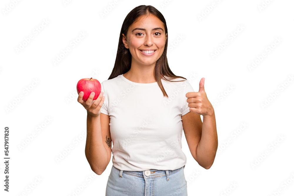 Young caucasian woman holding a red apple isolated smiling and raising thumb up Young caucasian woman holding a red apple isolated smiling and raising thumb up