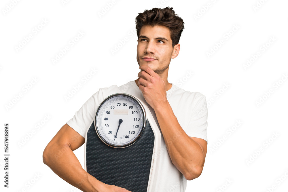 Young caucasian man holding a scale isolated looking sideways with doubtful and skeptical expression. Young caucasian man holding a scale isolated looking sideways with doubtful and skeptical expression.