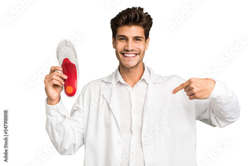 Young caucasian chiropodist man isolated person pointing by hand to a shirt copy space, proud and confident
