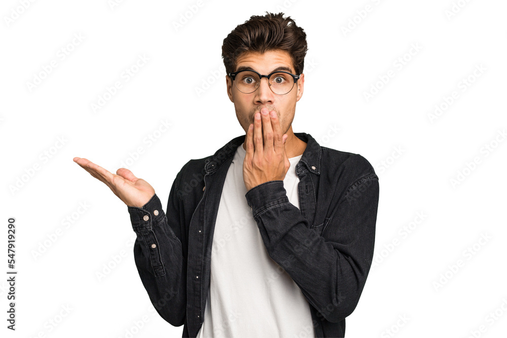 Young caucasian handsome man isolated impressed holding copy space on palm. Young caucasian handsome man isolated impressed holding copy space on palm.
