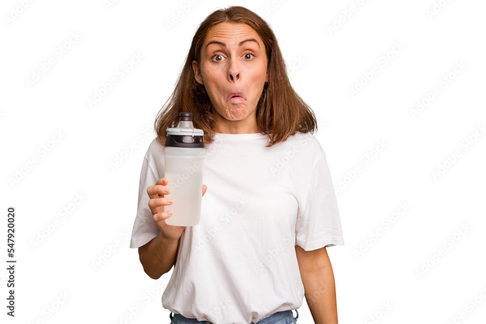 Young caucasian sport woman holding a bottle of water isolated shrugs shoulders and open eyes confused. Young caucasian sport woman holding a bottle of water isolated shrugs shoulders and open eyes confused.